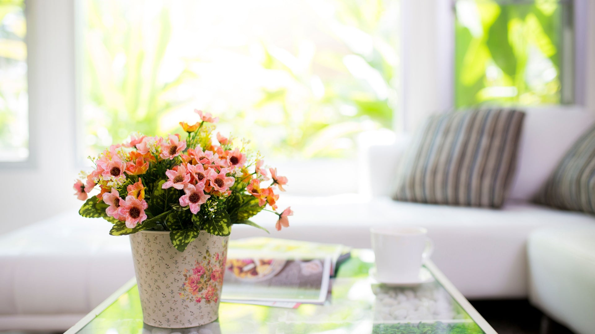 A bright living room with fresh flowers on a coffee table, creating a fresh and welcoming summer atmosphere.